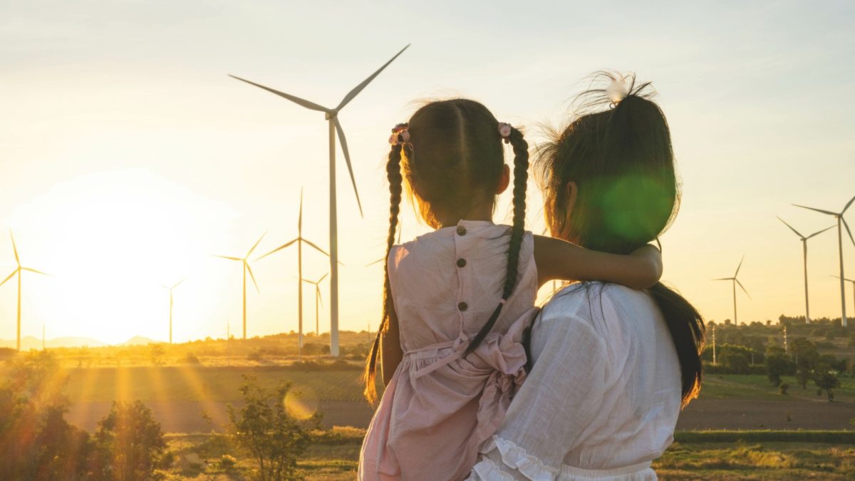 Mother and daughter starring at wind turbine